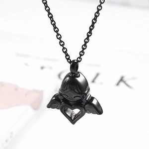 Macro view of a black electroplated angel wing heart pendant necklace on a magazine base
