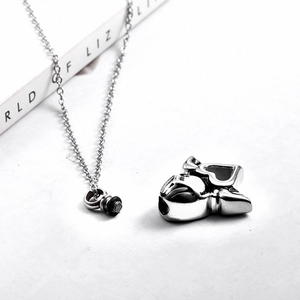 Macro shot of silver stainless steel bulldog cremation pendant with screw-top urn detail