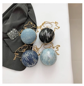 Detail of round spherical evening clutch bags with sequins and gold metal chain handles