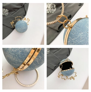 Detail view of denim blue spherical ball bag with gold chain and pearl handle accents