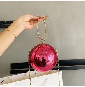 Dettaglio della borsa da sera tonda rosa specchio con manico ad anello dorato
