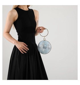 Detail of light blue spherical evening bag with silver sequins and metal ring handle
