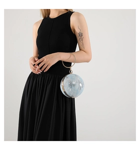 Detail of light blue spherical evening bag with diamond-set gold metal ring handle