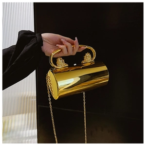 Close-up of golden cylindrical acrylic evening bag with lion head handle and metal chain