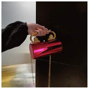 Detail of luxury fuchsia acrylic cylinder clutch with gold lion head handle and chain