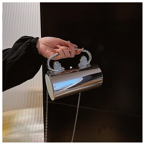 Detail of silver acrylic evening bag with lion head handles and chain strap