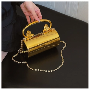 Macro view of golden cylindrical acrylic clutch with lion head relief and chain strap