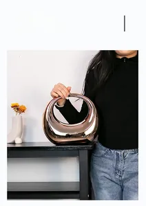 Vase artistique or rose brillant tenu à la main pour illustrer les dimensions réelles
