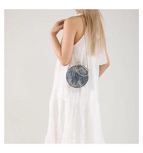 Chic blue denim ball bag with elegant gold chain strap and metal handle detail