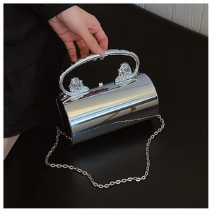 Close-up of silver cylindrical acrylic clutch with lion head relief and chain strap