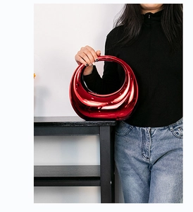 Vue détaillée du sac croissant rouge métallique brillant avec poignée en forme d'anneau