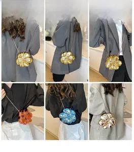 Detailed views of flower-shaped evening bags with metallic finish and metal chain straps
