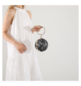 Detailed view of spherical evening bag with black sequins and gold crystal-embellished ring