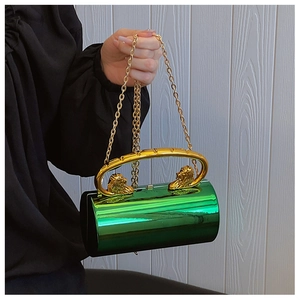 Detail of green acrylic cylinder clutch with gold lion head handles and chain strap