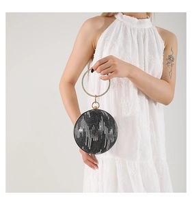 Detail of round evening clutch with silver sequins and large gold metal ring handle