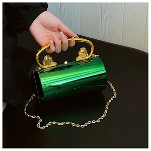 Detail of green metallic cylindrical bag with gold lion head handle and chain strap