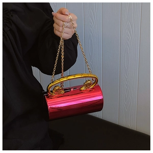 Detailed view of rose pink cylindrical evening clutch bag with golden lion head handle