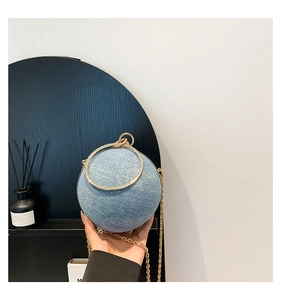 Detailed shot of spherical denim evening bag with rhinestones and metal ring handle