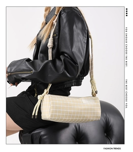 Vue détaillée du sac cylindre en nylon à carreaux avec une bandoulière en corde nouée