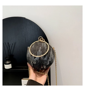 Detail of spherical evening bag with sequins and gold rhinestone ring handle