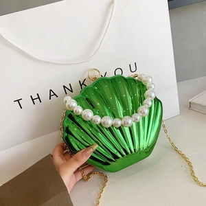 Metallic green shell-shaped clutch bag featuring a pearl handle and gold chain strap