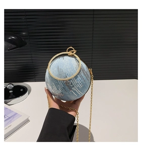 Detail of light blue spherical denim bag with silver sequins and rhinestone ring handle