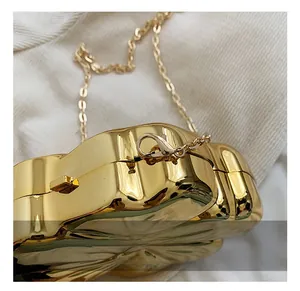 Macro shot of gold metal evening bag hardware with lobster clasp and chain link details