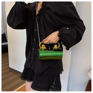 Detail of green metallic cylinder bag with lion head gold handle and chain strap