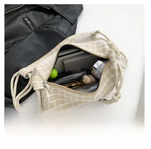Vue de dessus montrant la grande capacité de ce sac à bandoulière en nylon à carreaux