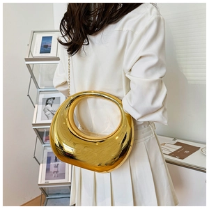 Bolso artístico de metal dorado en forma de media luna con acabado de espejo