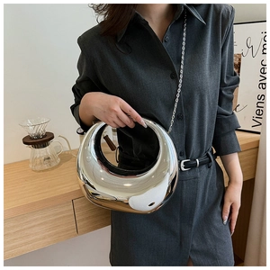 Detalle del bolso de luna plateado con efecto espejo y correa de cadena metálica