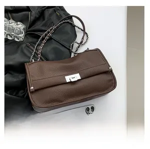 Detailed close-up of dark brown lychee grain leather bag with silver metal swivel lock