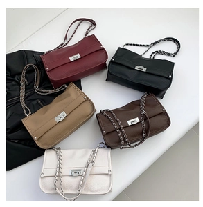 Top-down shot of leather messenger bags in five colors with silver chain straps