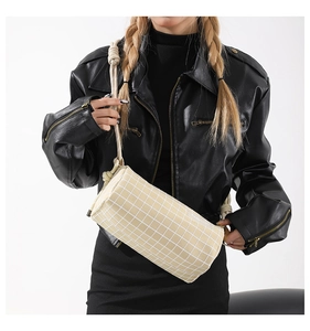 Détail du sac cylindre en nylon à carreaux avec bandoulière en corde de coton et logo