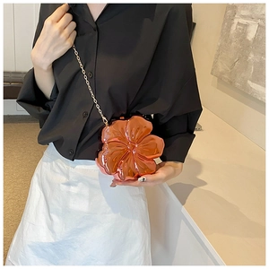 Detailed view of rose gold flower-shaped crossbody bag with polished mirror finish and chain