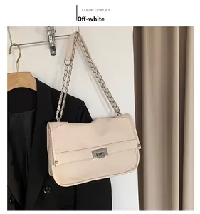 Detail of off-white lychee grain leather handbag with silver chain strap and metal lock