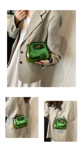 Macro view of bright green metallic crossbody bag with chain and oval handle grip