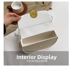 Interior view of white leather and beige fabric saddle bag with golden hardware