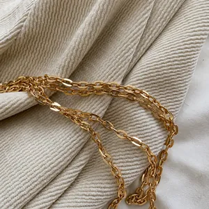 Close-up of polished gold metal chain strap on acrylic clutch with elegant detail