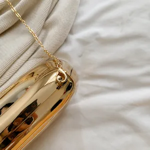 Detail of premium gold clasp and sturdy chain on a mirrored acrylic evening clutch bag