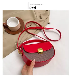 Detail of red leather saddle bag with gold buckle and brown striped fabric patchwork