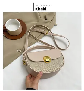Detail of khaki semicircular handbag featuring woven texture and gold spherical buckle