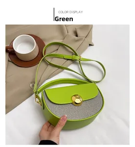Detail of green crescent handbag with striped woven panel and golden circular buckle lock