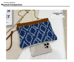 Size comparison between the blue denim crossbody bag and a smartphone for scale