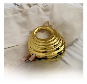 Macro shot of gold acrylic evening clutch with water ripple texture and chain strap