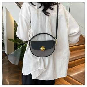 Close-up of minimalist half-moon crossbody bag with grey plaid fabric and golden clasp