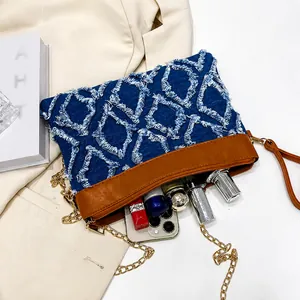 Detail view of denim quilted crossbody bag interior showing space for phone and makeup