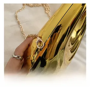 Detailed close-up of premium gold lobster clasp and chain on glossy evening handbag