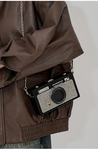Dettaglio della borsa a tracolla creativa a forma di fotocamera con strass e catena
