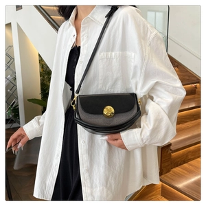 Chic black leather and gray textured fabric crossbody bag with a gold round metal buckle